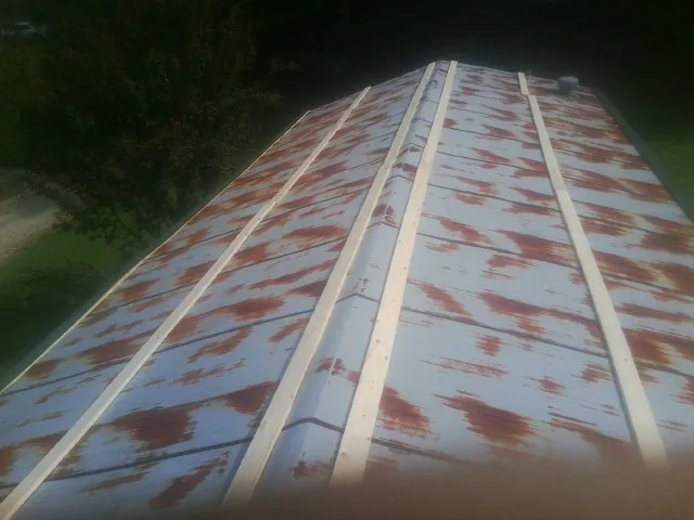 Rusted metal roof panels with new wood purlins before replacement — Storm Damage Roof Repair in Soldier by Roofing Brothers