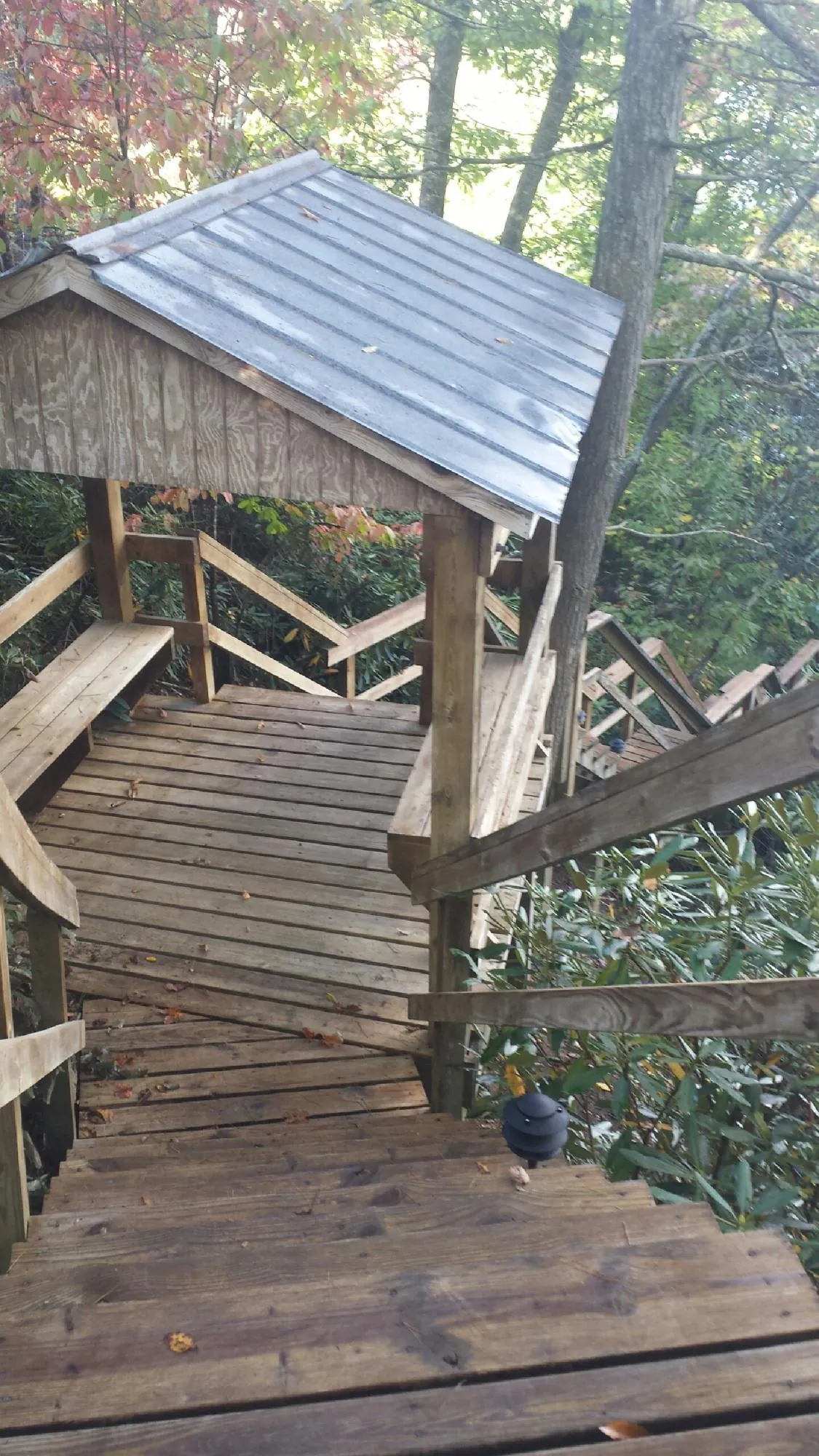Metal roofed shelter over wooden steps on a wooded walkway — Skylight Repair & Installation work by our crew in Soldier